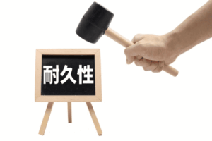 「耐久性」と書かれたミニ黒板とハンマー（金庫の耐久性と有効耐用年数についての解説イメージ）
